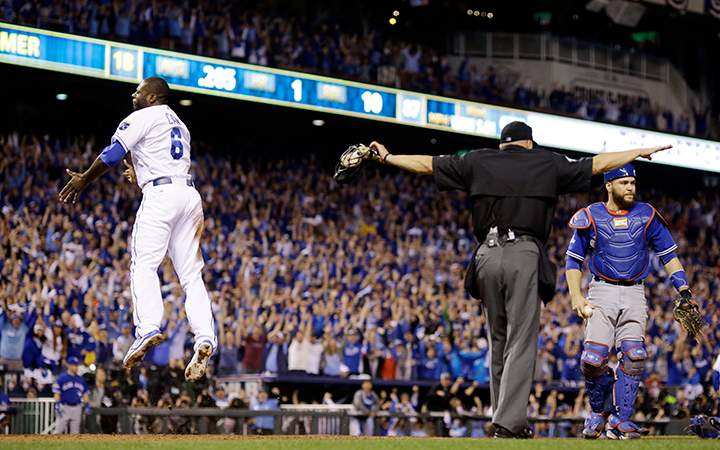 Kansas City Royals' Lorenzo Cain is safe at home past Toronto Blue Jays catcher Russell Martin on a hit by Eric Hosmer during the eight inning in Game 6 of baseball's American League Championship Series on Friday, Oct. 23, 2015, in Kansas City, Mo.
