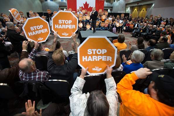 Supporters wave a "Stop Harper" signs as NDP leader Thomas Mulcair speaks at a rally in London, Ontario October 4, 2015. 