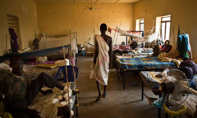 In this Saturday, Dec. 28, 2013 file photo, a man with gunshot wounds walks in a ward inside the Juba Military Hospital in Juba, South Sudan. 