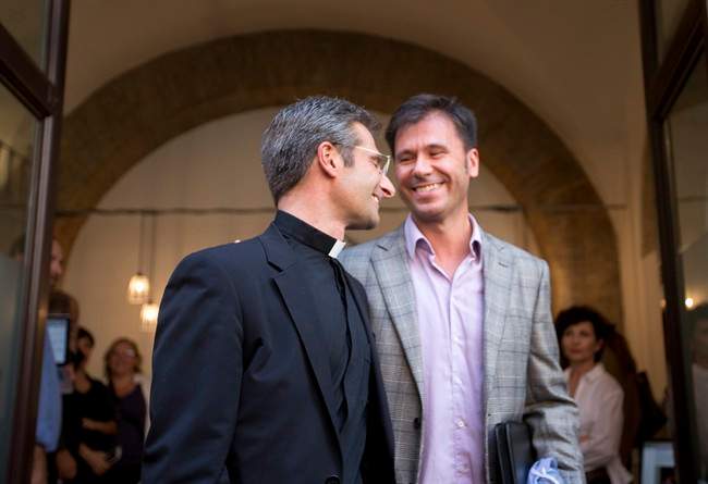 Monsignor Krzysztof Charamsa, left, and his partner Eduard, surname not given, leave a restaurant after a press conference in downtown Rome, Saturday Oct. 3, 2015. Vatican on Saturday fired a monsignor who came out as gay on the eve of a big meeting of the world's bishops to discuss church outreach to gays, divorcees and more traditional Catholic families.