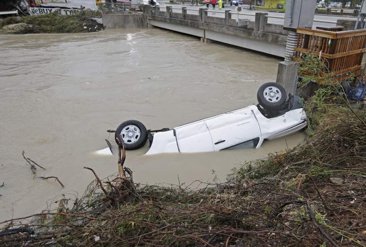 A pickup truck rests against the side of Gills Creek near a bridge in Columbia, S.C., Monday, Oct. 5, 2015.