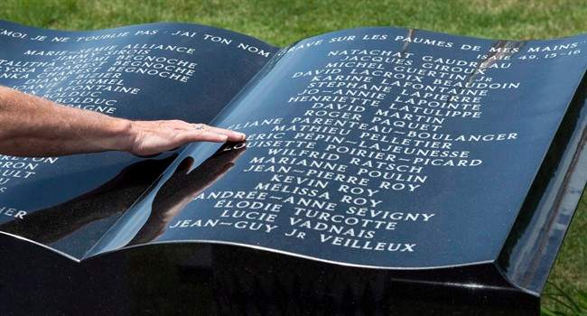 In this 2014 file photo, a man touches a stone monument in front of Ste-Agnes church following a memorial service for the 47 victims of an oil-filled train derailment in Lac-Megantic, Que. Residents of the small town are marking the fourth anniversary of the tragedy that killed 47 people and destroyed much of the downtown core. Thursday, July 6, 2017.