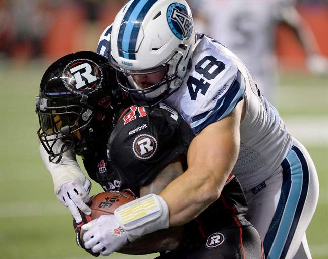 Former Toronto Argonauts linebacker Thomas Miles puts pressure on Jeremiah Johnson during a CFL game in Ottawa on Sept. 26, 2015.