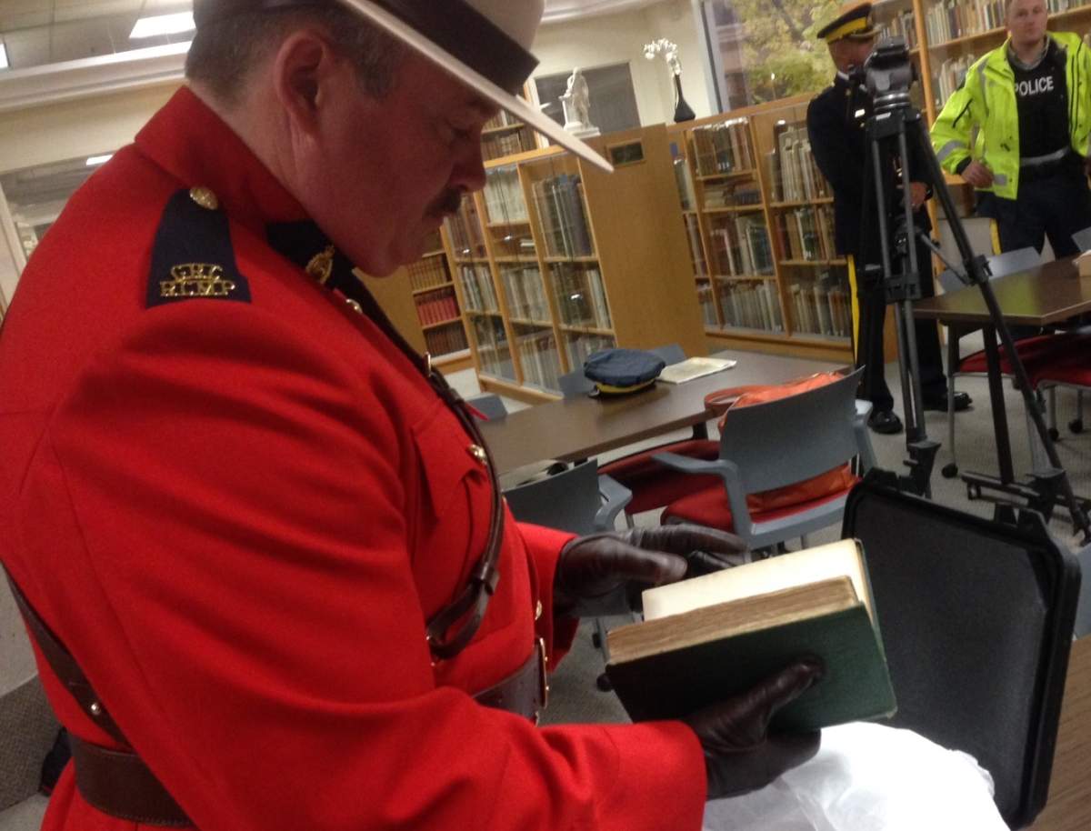 Const. Darryl Morgan flips through the pages of a fist edition copy of Charles Darwin’s “On the Origin of Species” at the MSVU library in Halifax on October 29, 2015.