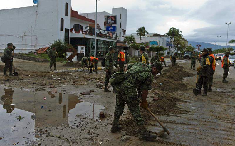 Mexican soldiers remove sand from the street in Manzanillo, state of Colima, after Hurricane Patricia hit the shore of neighbouring Jalisco state, on October 24, 2015.
