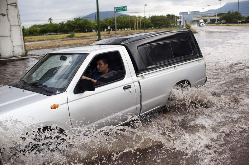 A truck drives through a flooded out turn off at the entrance to the city after heavy flooding from Hurriane Patricia October 24, 2015 in Tecoman, Colima, Mexico.
