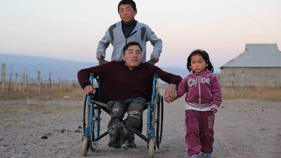 Nurgazy, the oldest of three siblings, is pushed to school every day by his younger brother Dastan.