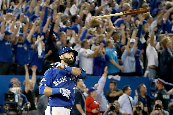 Jose Bautista of the Toronto Blue Jays throws his bat up in the air after he hits a three-run home run in the 7th inning against the Texas Rangers in Game 5 of the American League Division Series at Rogers Centre on October 14, 2015 in Toronto.