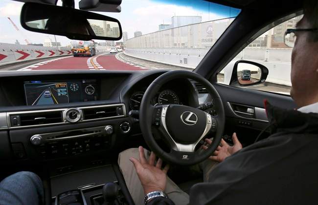 An employee of Toyota Motor Corp., drives automated driving test vehicle during a test drive of Toyota's self-driving technologies in Tokyo, Tuesday, Oct. 6, 2015. Toyota unveiled its vision for self-driving cars in a challenge to other automakers as well as industry newcomer Google Inc., promising to start selling such vehicles in Japan by 2020. Toyota Motor Corp. demonstrated on a regular Tokyo freeway Tuesday what it called the "mobility teammate concept," meaning the driver and the artificial intelligence in a sensor-packed car work together as a team.