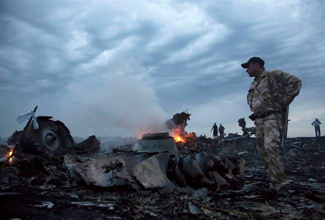 In this July 17, 2014 file photo, people walk amongst the debris at the crash site of a passenger plane near the village of Grabovo, Ukraine. Malaysia Airlines Flight 17 broke up high over eastern Ukraine in 2014, killing all 298 people on board. (AP Photo/Dmitry Lovetsky, File)