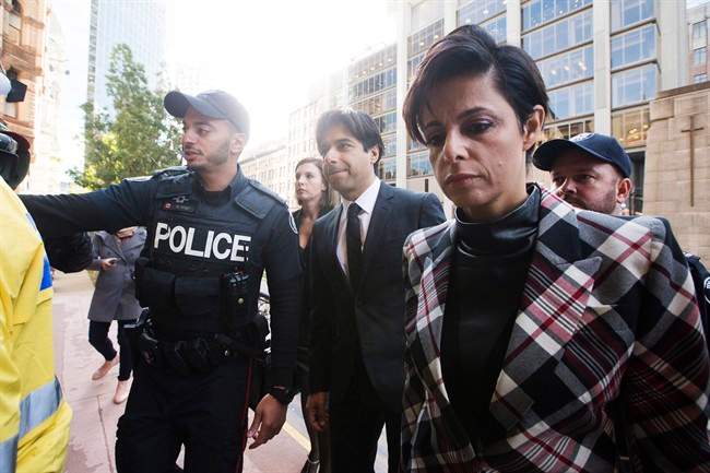 Police escort former CBC radio host Jian Ghomeshi, centre, who appears with his lawyer Marie Henein, right, for his pre-trial hearing for his sexual assault case in Toronto on Thursday, October 1, 2015. 