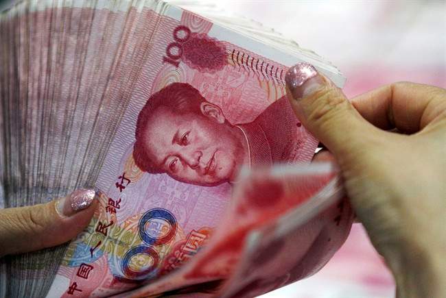 In this Tuesday, Aug. 11, 2015 photo, a bank clerk counts Chinese currency notes at a bank outlet in Huaibei in central China's Anhui province. Donald Trump has threatened to name China as a currency manipulator.
