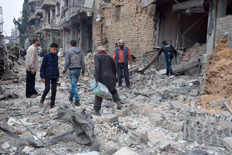 Residents inspect damage on the main field hospital in Douma after it was bombed by Syrian government air strikes in Douma, in north-east of Damascus suburb on October 29, 2015.