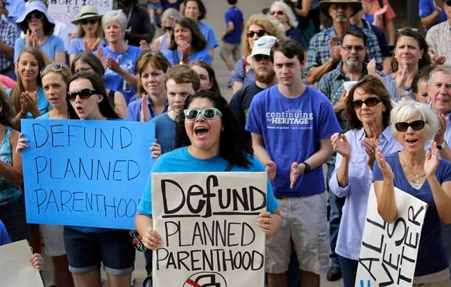 FILE - In this July 28, 2015, file photo, Erica Canaut, center, cheers as she and other anti-abortion activists rally on the steps of the Texas Capitol in Austin, Texas, to condemn the use in medical research of tissue samples obtained from aborted fetuses.