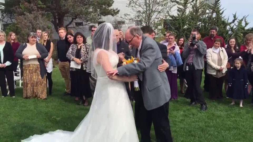 Wheelchair-bound father surprises daughter, walks her down aisle - image