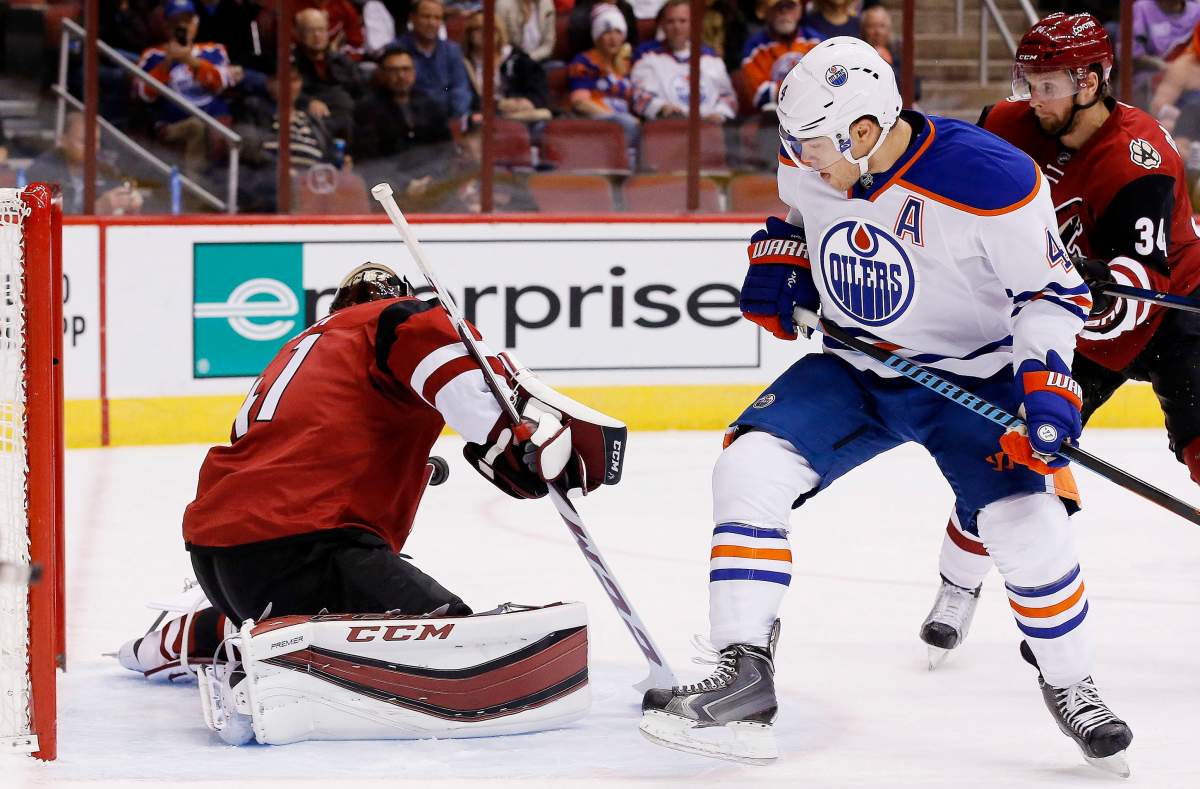 Edmonton Oilers’ Taylor Hall (4) has his shot stopped by Arizona Coyotes’ Mike Smith, left, as Coyotes’ Klas Dahlbeck (34) also defends during the first period of an NHL hockey game Thursday, Nov. 12, 2015, in Glendale, Ariz.