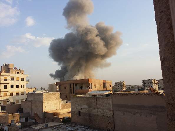 Smoke rises after air strikes by Syrian army  warplanes on the ISIL-held northern city of Raqqa, Syria on November 25, 2014. (Photo by Stringer/Anadolu Agency/Getty Images).