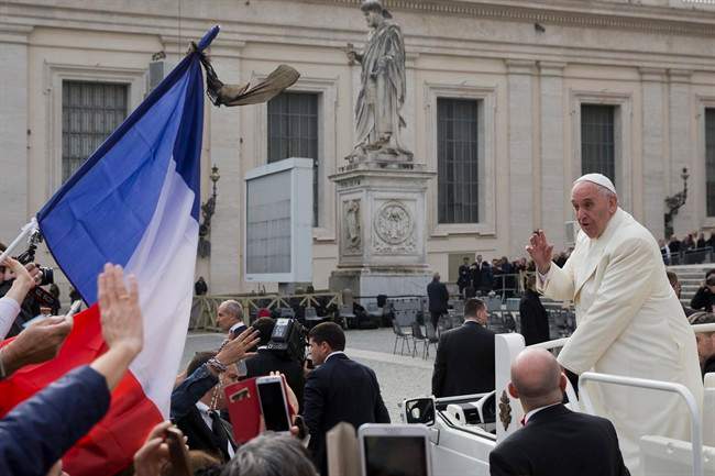 Pope Francis drives past a French flag as he leaves at the end of his weekly general audience, in St. Peter's Square, at the Vatican, Wednesday, Nov. 18, 2015.