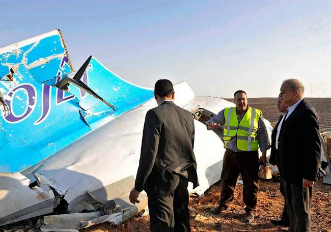 FILE - In this Saturday, Oct. 31, 2015, file photo released by the Prime Minister's office, Egyptian Prime Minister Sherif Ismail, right, looks at the remains of a crashed Russian passenger jet in Hassana, Egypt. Egyptian media have reacted with fury as Britain and the U.S. increasingly point to a bomb as the cause of the Russian plane crash, and many have hammered home to the public that their country is facing a Western conspiracy to scare off tourists and destroy the economy.