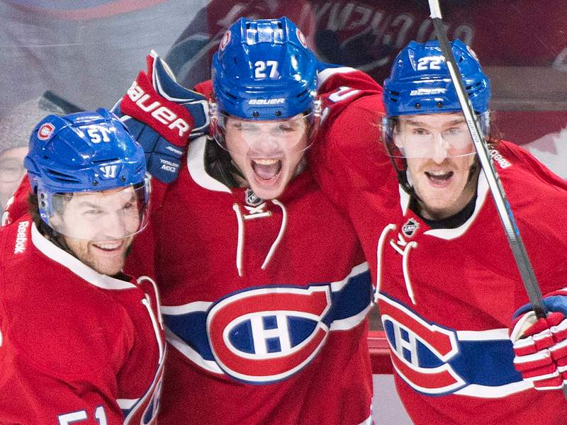 Montreal Canadiens' Alex Galchenyuk (27) celebrates with teammates David Desharnais (51) and Dale Weise after scoring against the New York Islanders during third period NHL hockey action in Montreal Sunday, November 22, 2015.