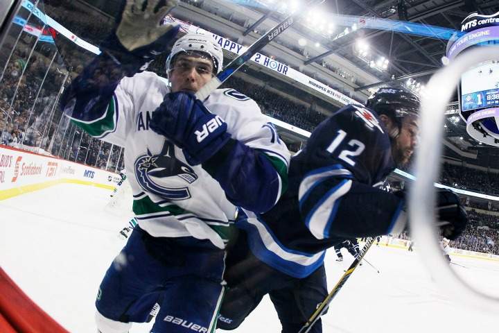 Vancouver Canucks' Jake Virtanen (18) and Winnipeg Jets' Drew Stafford (12) collide during second period NHL action in Winnipeg on Wednesday, November 18, 2015. 