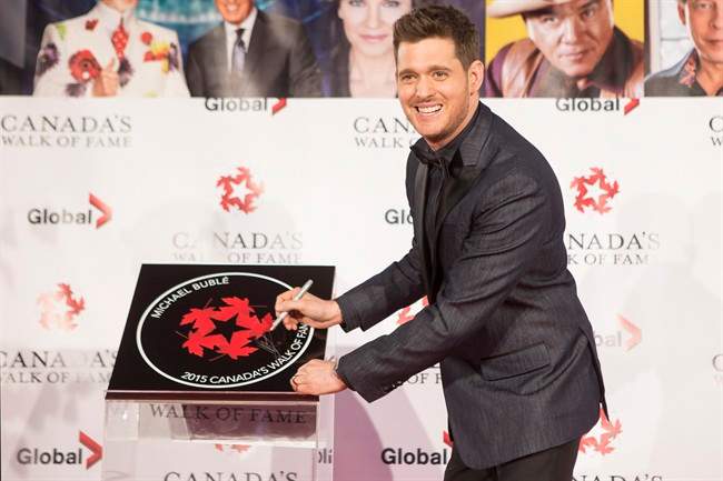 Michael Buble signs his plaque as he in inducted into Canada's Walk of Fame, during an event in Toronto on Saturday November 7, 2015.