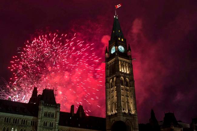 Fireworks explode behind the Peace Tower on Parliament Hill.