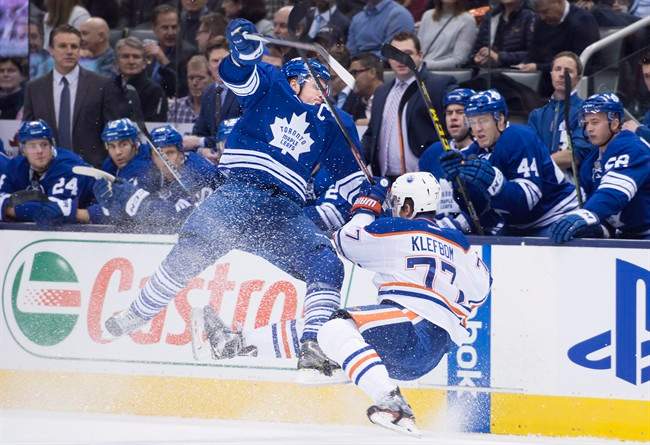 Toronto Maple Leafs' Dion Phaneuf, left, and Edmonton Oilers' Oscar Klefbom collide during first period NHL hockey action in Toronto on Monday, November 30, 2015.
