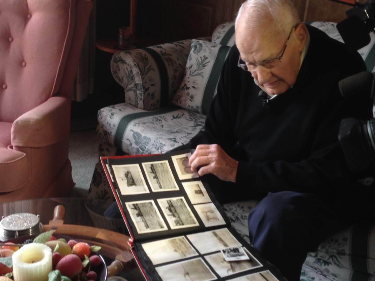 Doug Himmelman flips through old photos of the HMCS Sackville.