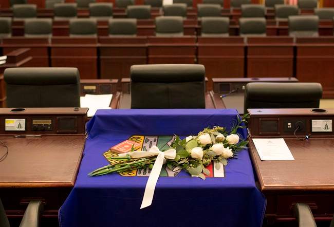 A flag and flowers are draped over the desk of MLA Manmeet Bhullar at the Alberta Legislature chambers in Edmonton Alta, on Tuesday November 24, 2015. Bhullar, 35, was killed in a car accident on Monday afternoon while driving from Calgary to Edmonton.