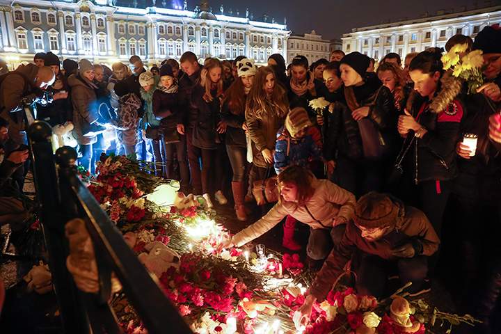 People light candles during a day of national mourning for the plane crash victims at Dvortsovaya (Palace) Square in St. Petersburg, Russia, on Sunday, Nov. 1, 2015.