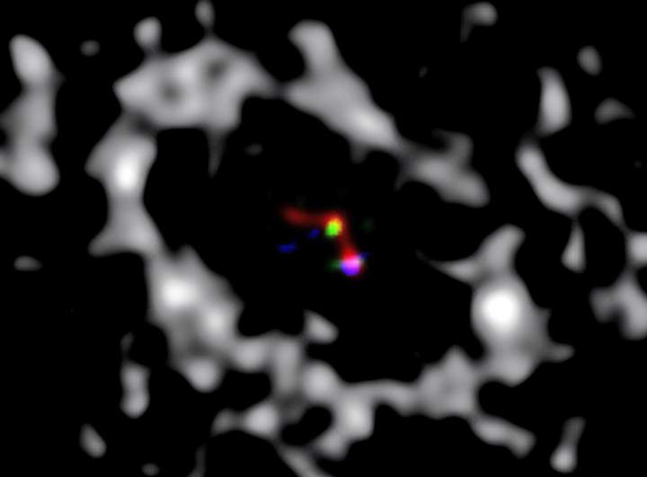 A composite image of the star and its planet forming. The grey material surround them is the accretion disk of dust and gases. 