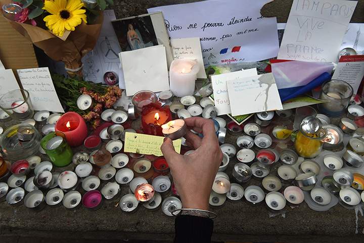 A person lights a candle during a minute of silence on November 16, 2015 on the Place du Capitole in Toulouse to pay tribute to victims of the attacks in Paris.