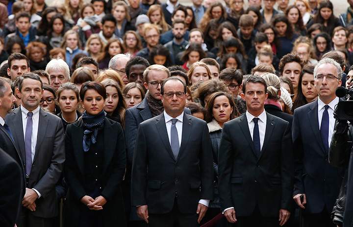 French President Francois Hollande (centre), flanked by French Prime Minister Manuel Valls (second right) and French Education Minister Najat Vallaud-Belkacem, (second left) stand among students during a minute of silence in the courtyard of the Sorbonne University in Paris, Monday, Nov. 16 2015.