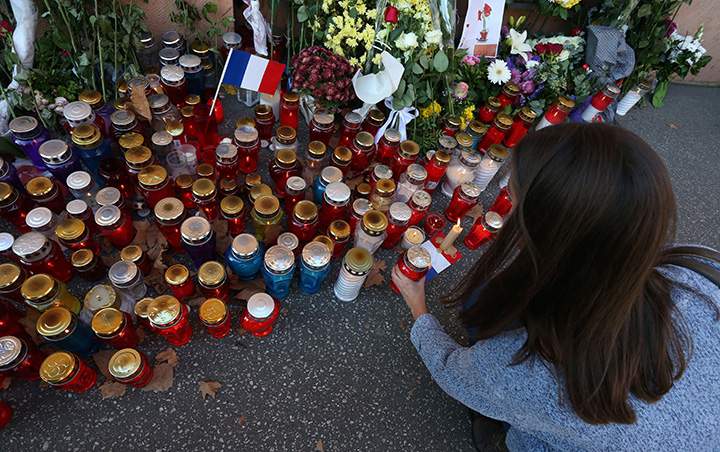 A woman places a candle prior to a minute of silence on November 16, 2015 in front of the French Embassy in Zabreb, to pay tribute to victims of the attacks in Paris.