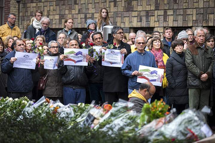 People observe a minute of silence on November 16, 2015 at the French Embassy in The Hague to pay tribute to victims of the attacks in Paris.