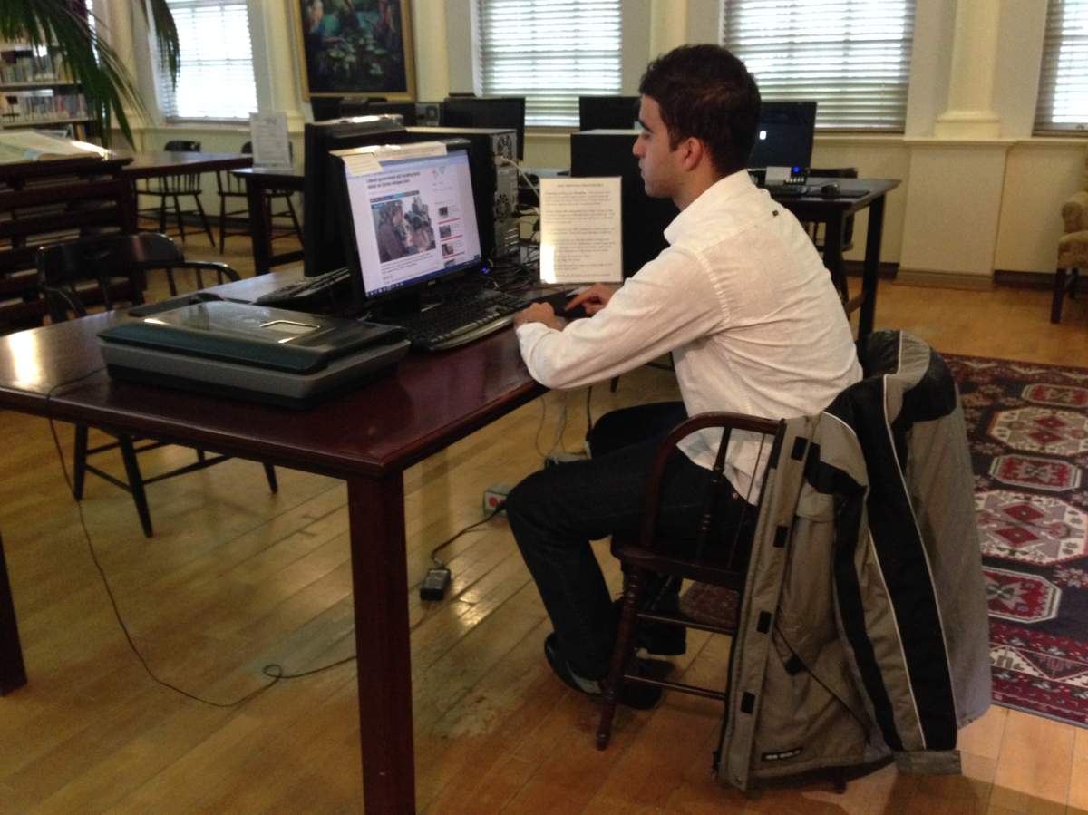 Nawris uses a computer to check on stories about the war in Syria.