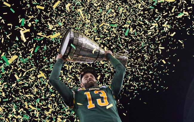 Edmonton Eskimos quarterback Mike Reilly hoists the Grey Cup after his teams win over the Ottawa Redblacks during the 103rd Grey Cup in Winnipeg, Man., Sunday, Nov. 29, 2015. 