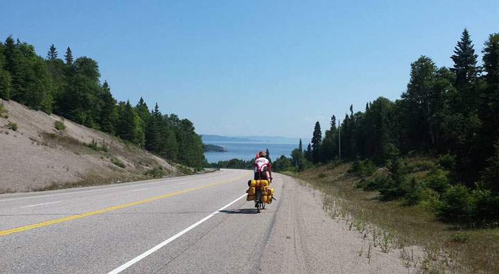 This photo shows Rob Howse biking in July 2015 near Lake Superior.