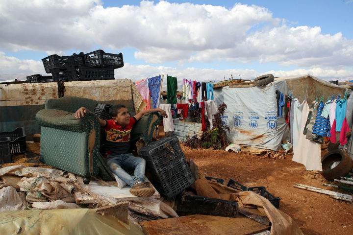 A Syrian refugee boy sits on November 15, 2015, at a makeshift camp by Taybeh village, in Lebanon's eastern Bekaa Valley.