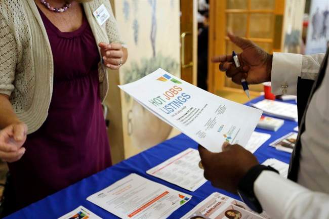 In this Tuesday, Oct. 6, 2015, photo, military veteran Mark Cannon, of Miami,  talks about employment opportunities at a job fair for veterans, in Pembroke Pines, Fla. 