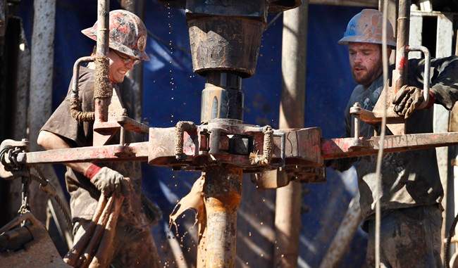 Feb. 21, 2012 file photo of oil field workers  using a drill.