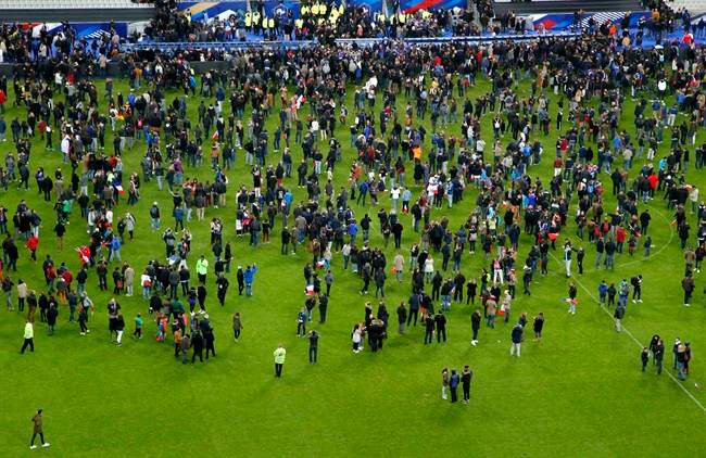 Spectators invaded the pitch of the Stade de France stadium after explosions were heard during the international friendly soccer France against Germany, Friday, Nov. 13, 2015 in Saint Denis, outside Paris.
