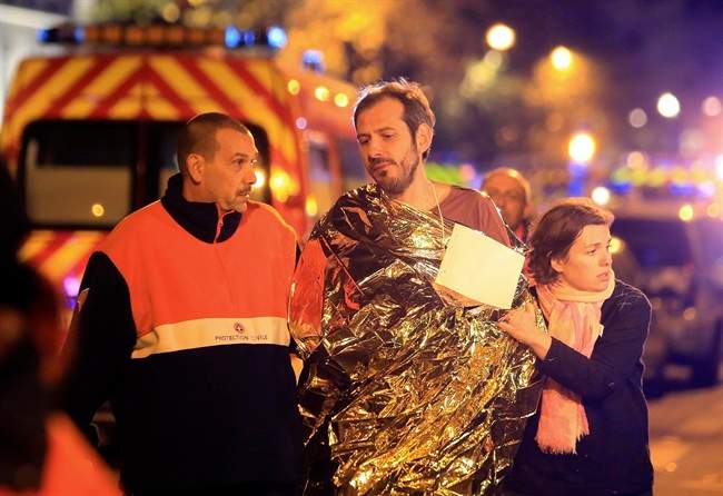 A man is being evacuated from the Bataclan theater after a shooting in Paris, Friday Nov. 13, 2015. French President Francois Hollande declared a state of emergency and announced that he was closing the country’s borders.