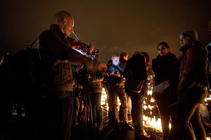 A man plays violin on November 20, 2015 during a gathering on the water mirror on the esplanade of the Chateau des Ducs in Nantes, western France, to pay tribute to the victims of the attacks of November 13.