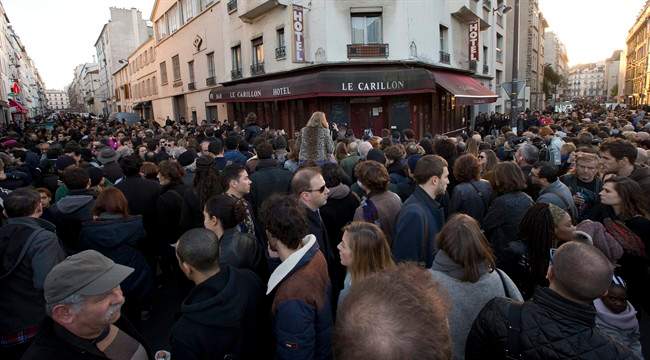 People pay their respect to the victims at the site of the attacks on restaurant Le Petit Cambodge (Little Cambodia) and the Carillon Hotel on the first of three days of national mourning in Paris, Sunday, Nov. 15, 2015. 