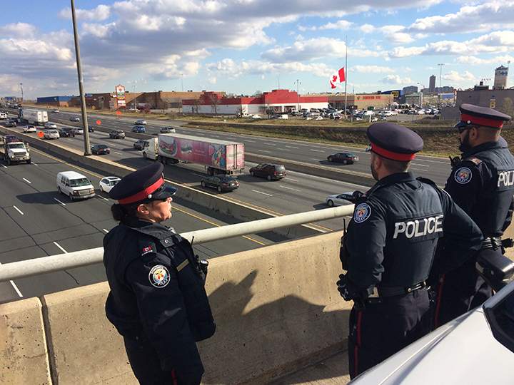 Police await the procession for John Gallagher on a bridge overlooking the Highway of Heroes on Nov. 20, 2015.