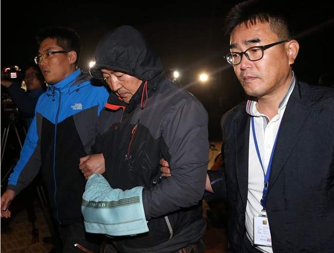 FILE - In this April 19, 2014 file photo, Lee Joon-seok, center, the captain of the sunken ferry Sewol in the water off the southern coast, leaves a court which issued his arrest warrant in Mokpo, south of Seoul, South Korea. South Korea's top court on Thursday, Nov. 12, 2015, upheld a lifetime sentence for the captain of the ferry that sank last year, killing more than 300 people, most of them teenagers on a school trip. (Yonhap via AP, File) KOREA OUT.