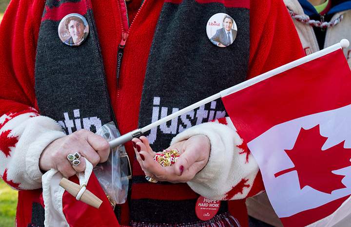 A woman wears campaign buttons with the image of Prime Minister-designate Justin Trudeau before his swearing-in ceremony at Rideau Hall in Ottawa on Wednesday, Nov. 4, 2015.