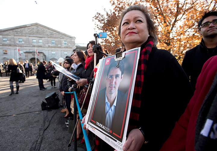 A member of the public holds a Justin Trudeau campaign poster before the swearing-in ceremony of Prime Minister-designate Justin Trudeau at Rideau Hall in Ottawa on Wednesday, Nov. 4, 2015.